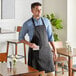 A man wearing a black Choice apron standing in a professional kitchen.