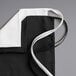 A black polyester waist apron with three white pockets and white ties.