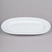 An Arcoroc white porcelain oval platter with a rim.