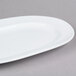 A white oval porcelain platter with a curved edge.