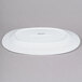 An Arcoroc white oval porcelain platter with black text reading "Arc Cardinal" on the bottom.