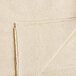 A folded edge on a Monarch Brands beige canvas drop cloth.