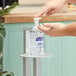 A person using a Purell hand sanitizer pump.