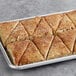 A tray of David's Cookies Cinnamon Chip Scone Dough triangles on a gray surface.