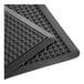 A close-up of a black Lavex BubbleFlex rubber mat with holes.