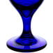 A close-up of a Libbey cobalt blue iced tea glass with a stem.