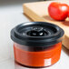 A ARY VacMaster 0.5 Qt. Vacuum Canister of red tomato sauce on a counter with a tomato in it.