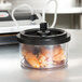 A plastic ARY VacMaster vacuum container on a counter with food inside and a black lid.