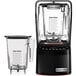 A black Blendtec blender with a clear container.