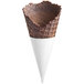 A brown JOY cookies and creme waffle cone in a white cone holder with a black handle.