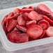A plastic container filled with sliced strawberries.