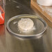A ball of pizza dough on an American Metalcraft aluminum pizza pan.