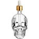 An Acopa clear glass skull bitters bottle with a dropper.