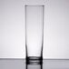 A Libbey straight sided glass filled with a clear liquid on a table.