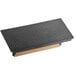 A black rectangular Choice cast iron steak weight with a wooden handle on a black and grey surface.