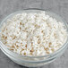 A bowl of White Pearlized Snowflake Sprinkles on a white background.