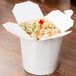 A white SmartServ take-out container with food inside.
