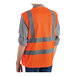 A person wearing a Lavex orange safety vest with reflective stripes.
