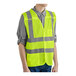 A man wearing a lime high visibility safety vest.