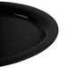 A close-up of a black oval platter with a curved edge.