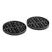A pair of black waffle plates with holes in them.