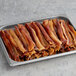 A tray of Umaro plant-based vegan bacon strips on a gray surface.
