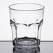 A close up of a clear Carlisle plastic tumbler with a faceted rim.