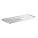 A stainless steel rectangular drain tray with a curved design and a hole in the middle.