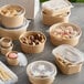 A group of Choice round plastic take-out containers filled with food and topped with clear lids.
