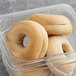 A clear plastic container with a Greater Knead plain bagel inside.