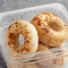 A plastic container with three Greater Knead Gluten-Free Onion Bagels inside.