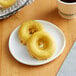 Two Southern Roots vegan lemon drop cake donuts on a plate.