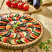 A table set with a round vegetable tart in a de Buyer fluted stainless steel mold.