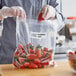 A person in gloves putting strawberries into a Berry food grade storage bag.