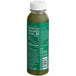 A Suja Mighty Dozen green beverage bottle with white text and cap.