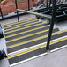 A set of stairs with black and yellow striped treads.