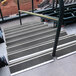 A set of Wooster Flexmaster stair treads with black grit surfaces on metal stairs.