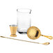 A gold Barfly cocktail mixing kit on a white background including a strainer, shaker, and bar spoon.