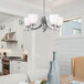 A modern kitchen with a Canarm Mack brushed nickel chandelier hanging over a table.