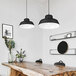 A wood table with a Canarm Levi matte black pendant light above it and a chair.