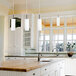 A Canarm Helena brushed pewter pendant light over a white kitchen.