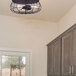 A Canarm Flora matte black caged semi-flush mount ceiling light in a home kitchen.