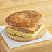 A Timber Ridge Farms bagel thin breakfast sandwich with egg and cheese on a wooden surface.