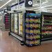 A Marco Company double-sided refrigerator end cap display with adjustable shelves full of bags of vegetables and a variety of food.
