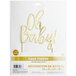 A white package with a gold "Oh Baby!" foil cake topper on top.