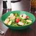A rainforest green melamine bowl filled with salad, shrimp, and vegetables.