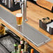 A Regency stainless steel beer drip tray under a beer tap on a metal counter.