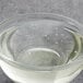 A clear glass bowl filled with Malt Products RiceRite Rice Syrup over a bowl of water with bubbles in it.
