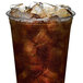 A plastic cup filled with brown liquid and ice made by a Scotsman Prodigy Elite Series low-side ice machine.