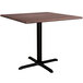 A Lancaster Table & Seating Excalibur square table with a walnut top and black base.